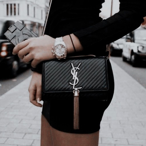 pulseiras masculinas: menina com bolsa Yves Saint Laurent e relógio.